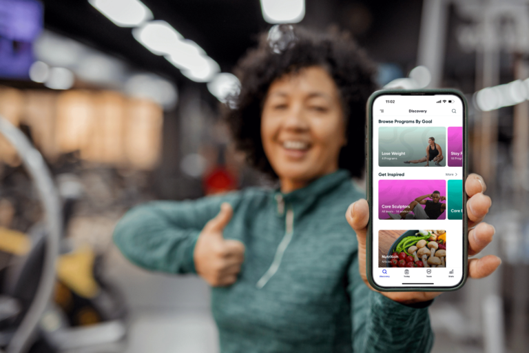 woman with thumbs up showing mobile with app screen